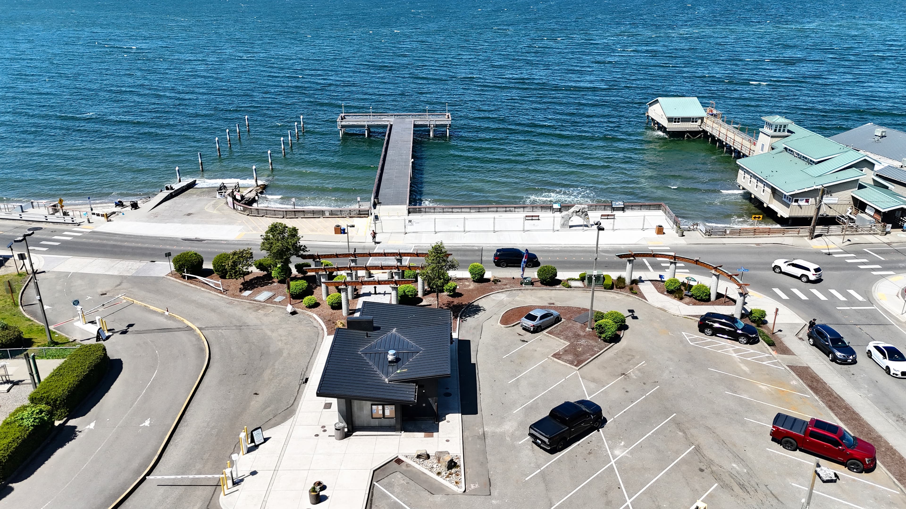 Aerial view of the Redondo Beach pier, visitor center, and parking arch on a clear day in Des Moines, WA